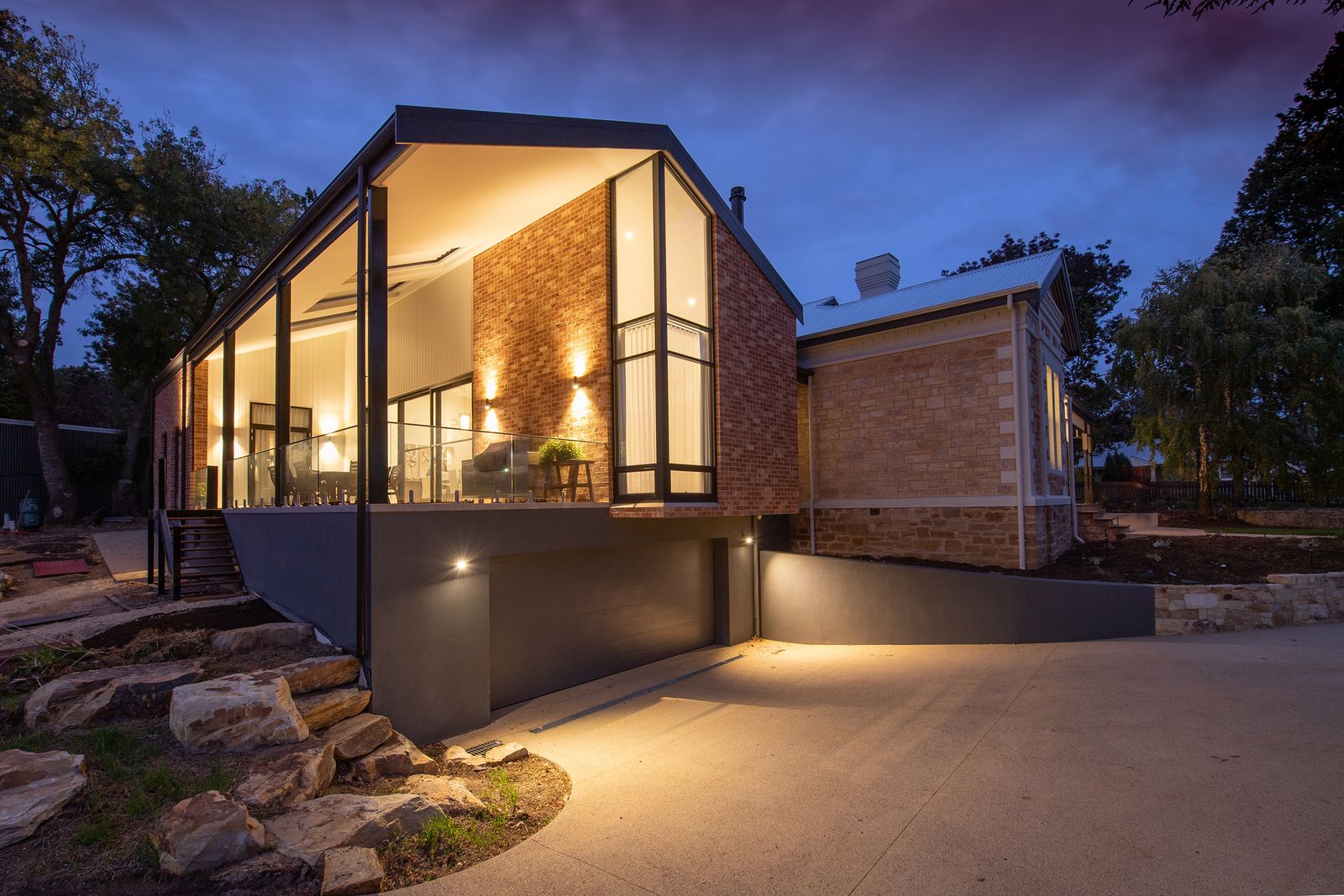 Fachada da Casa Ipê ao entardecer, com luzes acesas